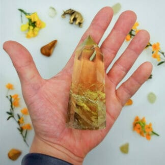 Citrine single point 151-200g on hand with crystals in background